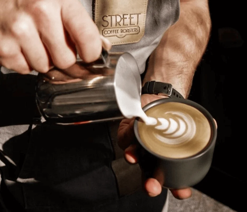 Barista Street Coffee pregătind latte art